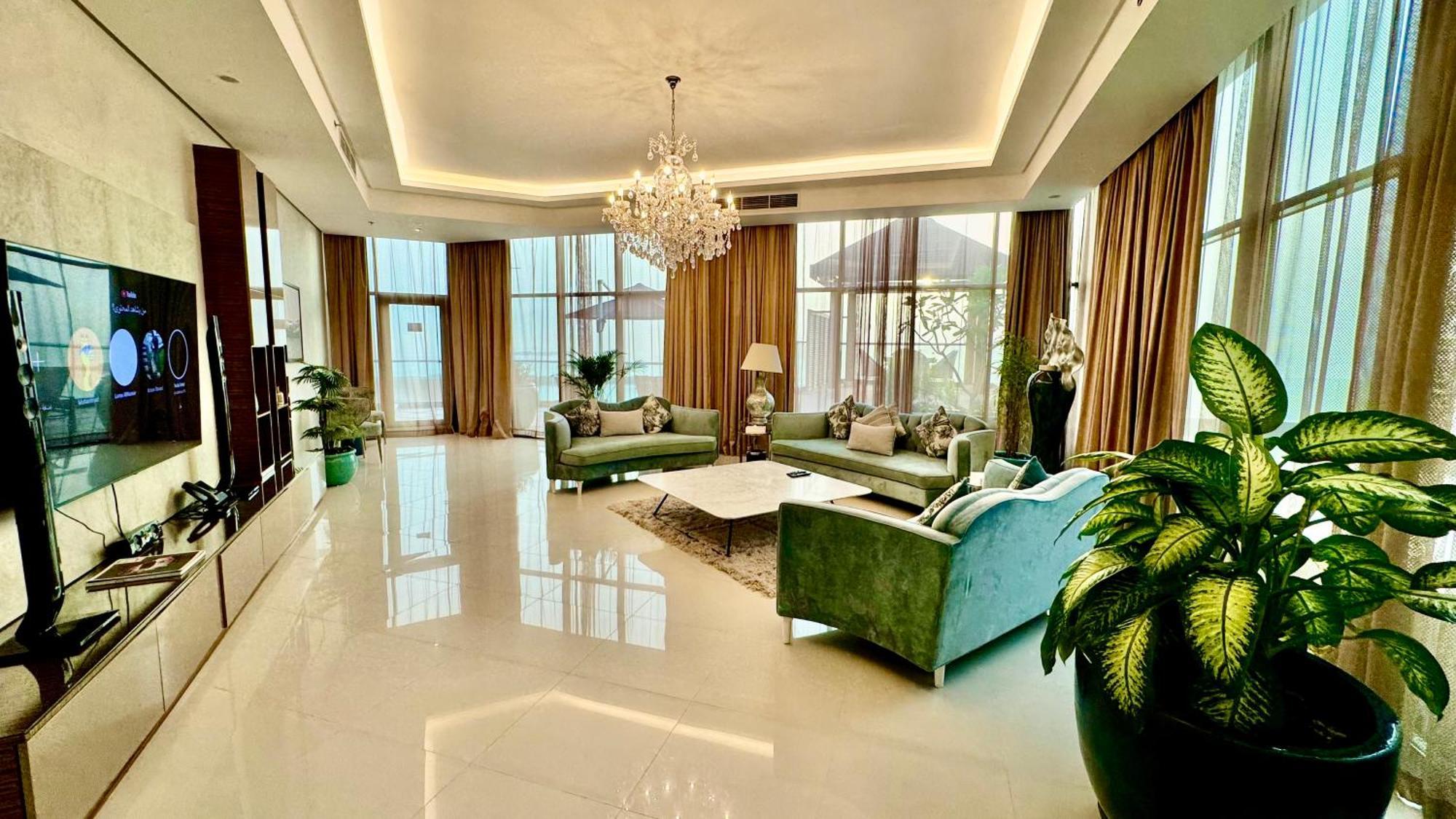 Lagoona Beach Luxury Resort And Spa Manama Ngoại thất bức ảnh The photo depicts a spacious and elegantly designed living room. The room features large windows allowing natural light to flood in, accompanied by sumptuous curtains. The furniture includes a pair of soft green sofas and a centerpiece coffee table s