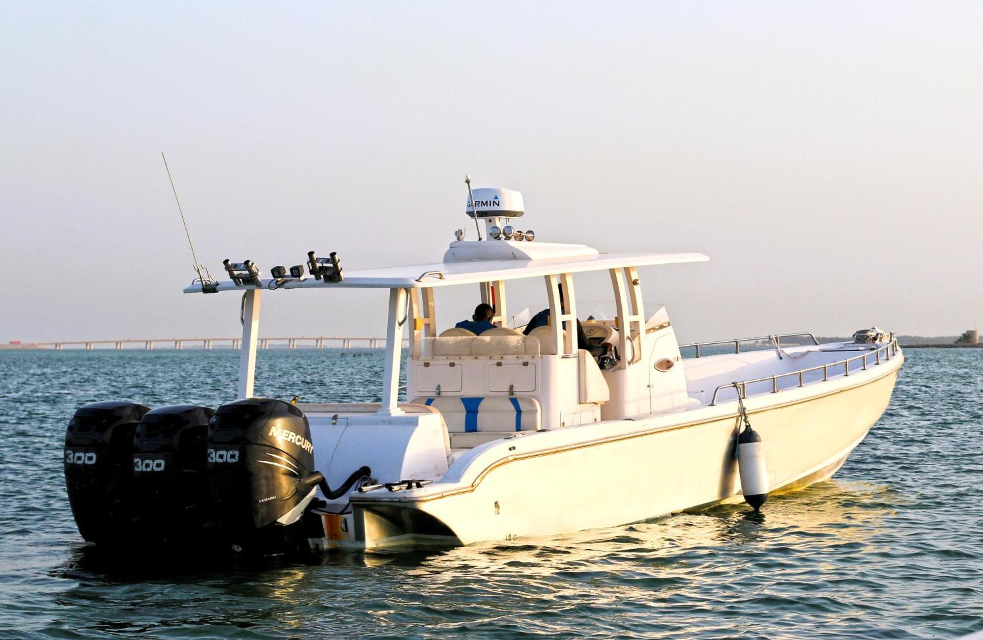 Lagoona Beach Luxury Resort And Spa Manama Ngoại thất bức ảnh The photo shows a large, white motorboat equipped with three powerful outboard engines at the stern. The boat has a sleek design, with a spacious open deck and a covered cabin area that likely provides shelter and controls for navigation. The scene i