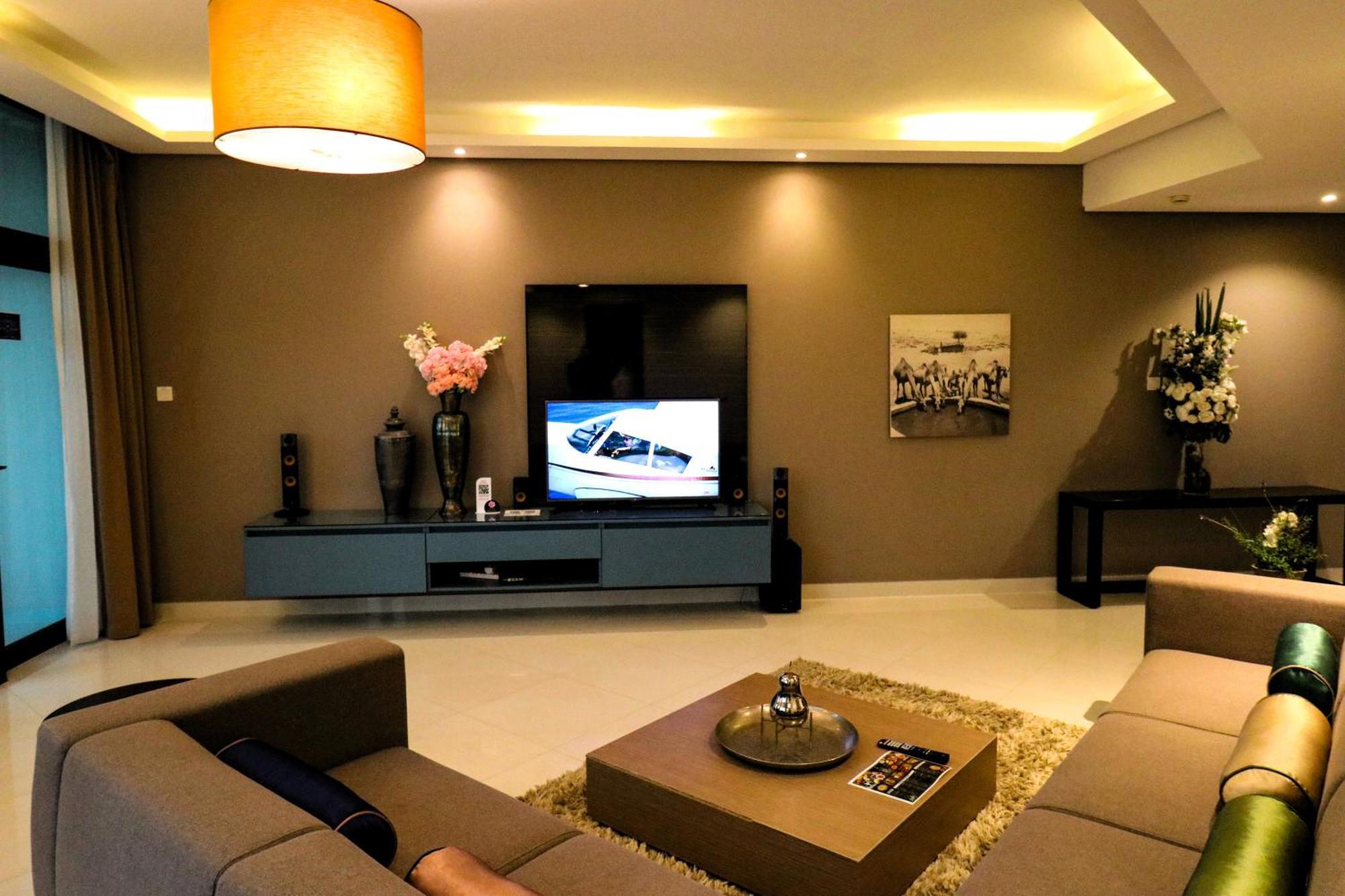 Lagoona Beach Luxury Resort And Spa Manama Ngoại thất bức ảnh The photo shows a modern living room with a neutral color palette. Key features include:

- A comfortable seating area with a sofa arranged around a coffee table.
- A minimalist coffee table with a decorative item on top.
- A large flat-screen televi